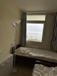 a bedroom with a bed and a window with the beach at Strandhotel Wohnung 33 in Dahme