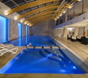 a swimming pool in a building with blue water at Hotel Cristal in San Carlos de Bariloche