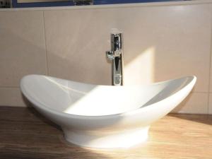 een witte wastafel met een kraan in de badkamer bij Holiday apartment "Sun Catcher" in Dierhagen +11 foto's