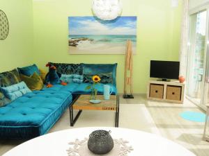 een woonkamer met een blauwe bank en een tv bij Holiday apartment "Sun Catcher" in Dierhagen