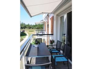 een terras met een tafel en stoelen op een balkon bij Holiday apartment "Sun Catcher" in Dierhagen