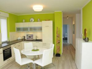 een keuken met een witte tafel en witte stoelen bij Holiday apartment "Sun Catcher" in Dierhagen