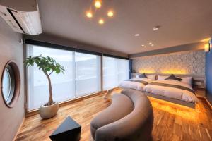 a bedroom with a bed and a couch and a tree at SAZANAMI LAKE FRONT in Fujikawaguchiko +29 photos