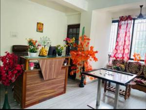 a living room with a table and flowers in it at Chennai Grand T Nagar in Chennai