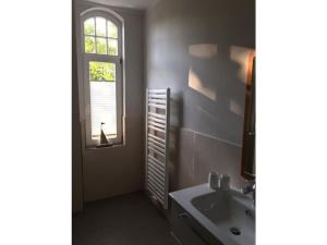 baño con lavabo y ventana en Art Nouveau villa am See, en Ascheberg