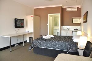 a hotel room with a bed and a desk at Pinjarra Resort in Pinjarra