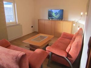 a living room with two chairs and a table and a tv at Holiday apartment Heitmann in Hilders