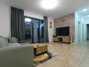 sala de estar con sofá y TV de pantalla plana en Къща за гости Софаш 