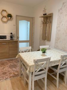 eine Küche und ein Esszimmer mit einem Tisch und Stühlen in der Unterkunft Belvárosi Levendula Apartman Gyula in Gyula