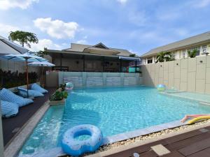 a swimming pool with a pool noodle in front of a house at Patong Bay Residence in Patong Beach