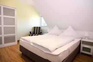 Schlafzimmer mit einem Bett mit weißer Bettwäsche und einem Fenster in der Unterkunft Farmstay Neuendorfkrug L tow in Lütow