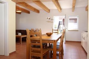 eine Küche und ein Esszimmer mit einem Holztisch und Stühlen in der Unterkunft Farmstay Neuendorfkrug L tow in Lütow