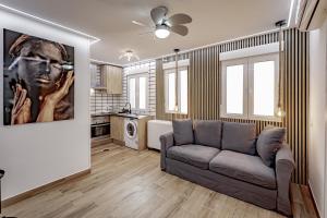 una sala de estar con sofá y una pintura en la pared en Apartamentos Estrecho, en Madrid
