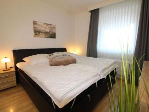 a large bed in a bedroom with a window at Nice apartment near beach in Cuxhaven