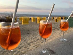 three wine glasses sitting on a table on the beach at Nice apartment near beach in Cuxhaven