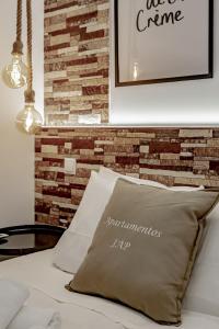 una almohada sentada en una cama junto a una pared de ladrillo en Apartamentos Estrecho, en Madrid