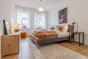 a bedroom with a bed and a table with a lamp at Stilvolles City-Apartment I WLAN l Küche I Zentral I 8P in Schwarzenberg