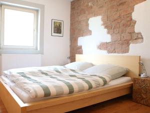 uma cama num quarto com uma parede de tijolos em Holiday apartment Faller-Greiner em Bad Bergzabern