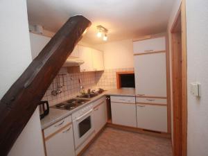 uma pequena cozinha com armários brancos e um fogão em Holiday apartment Luxhof em Sankt Märgen