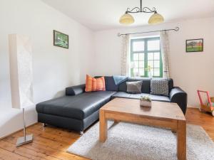 Sala de estar con sofá de cuero negro y mesa de centro en Lovely Holiday Home in Zierow with Terrace en Zierow