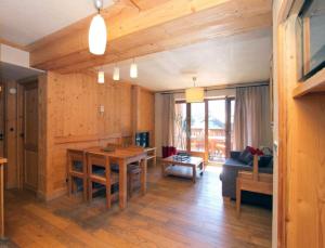 sala de estar con mesa y sofá en Cortina 32 Appt terrasse somptueuse 4-6 pers, en Les Deux Alpes
