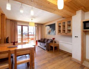 sala de estar con mesa y sofá en Cortina 32 Appt terrasse somptueuse 4-6 pers, en Les Deux Alpes