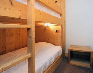 1 dormitorio con 2 literas y mesa en Cortina 32 Appt terrasse somptueuse 4-6 pers, en Les Deux Alpes