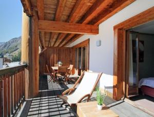 Habitación con balcón con mesa y sillas. en Cortina 32 Appt terrasse somptueuse 4-6 pers, en Les Deux Alpes