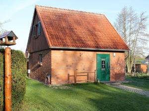 un granero de ladrillo rojo con una puerta verde en Lovely Holiday Home in Zierow with Terrace en Zierow