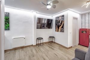 Sala de estar con 2 taburetes y pinturas en la pared en Apartamentos Estrecho, en Madrid