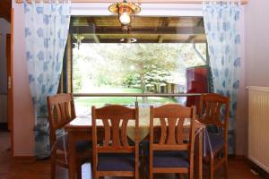 a dining room with a table and chairs and a window at Holiday home lake view Zemitz in Zemitz