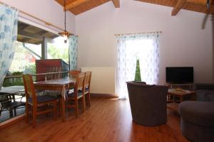 a living room with a table and chairs and a television at Holiday home lake view Zemitz in Zemitz