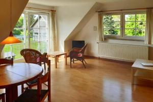 a living room with tables and chairs and windows at Apartments Blue House Putbus in Putbus