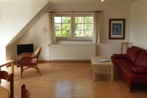 a living room with a red couch and a window at Apartments Blue House Putbus in Putbus
