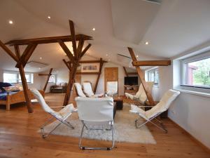 uma sala de estar com cadeiras brancas e uma mesa em Exquisite Mansion in Pugholz near Sea em Hasselberg