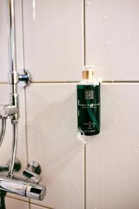 a green bottle on a wall in a bathroom at Clarion Collection Hotel Smedjan in Sandviken