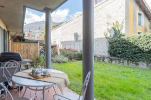 un tavolo e sedie su un patio con cortile di Ponente Balcony & Garden by Rent All Como a Gravedona