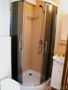 a shower with a glass door in a bathroom at Szyper 2 in Jastarnia