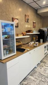 a kitchen with a counter with a refrigerator at Adonis Arc Hotel Aix in Aix-en-Provence