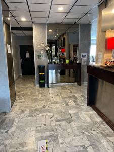 a lobby with a reception desk and a tile floor at Adonis Arc Hotel Aix in Aix-en-Provence