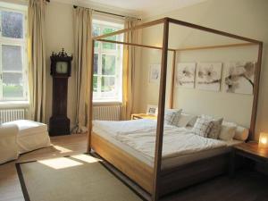 a bedroom with a canopy bed and a clock at Apartment in Garz with bicycle storage in Garz-Rügen