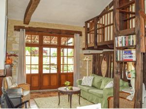 sala de estar con sofá verde y estante para libros en Snug cottage in Saint Eutrope De Born with pool, en Saint-Eutrope-de-Born