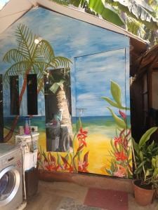 a painting on the side of a house with a washing machine at Tides by TB in Canacona