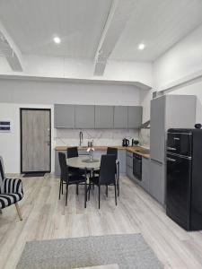 a kitchen with a table and chairs and a black refrigerator at Apartment Valgeranna in Audru
