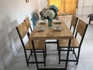 a wooden table with chairs and a vase of flowers at Cozy roomy condo near Big C and Payap University in Chiang Mai