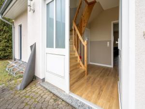 eine Tür, die zu einem Flur mit Holzboden führt in der Unterkunft Winsome Apartment in Bastorf with Private Garden in Bastorf