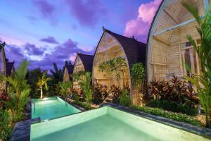 an exterior view of a villa with a swimming pool at ila gaia Bali in Canggu