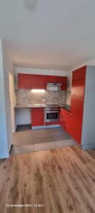 an empty kitchen with red cabinets and a stove at Studio Apartment Nähe S-Bahn in Oberesslingen