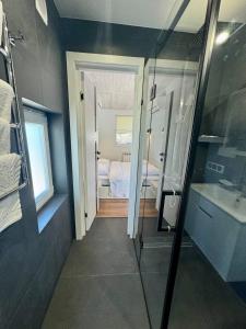 a bathroom with a shower and a sink and a bedroom at Shtil in Kyiv