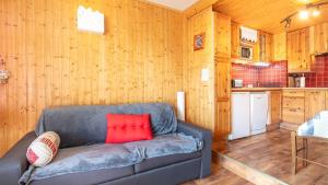 a living room with a couch and a kitchen at Hippocampe 20 - Appt cosy 4-6 pers in Chamrousse